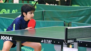 Aadil awaits in his returning position for the serve of his opponent on August 23, 2015. He competed in a Euro Mini which is the most prestigious TT championship in all of Europe for the Under 11 age group. This tournament took place in Schiltigheim, France and Aadil came in 6th place (photo courtesy Anand family).