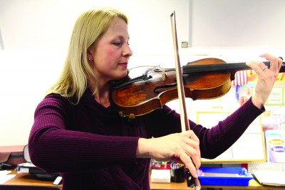 Ms. Anna Salmi, who just got back from maternity leave, plays the violin (photo by Cloe Tchelikidi).