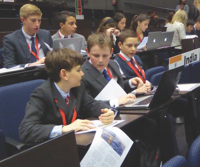 MADMUN participants Yannis Lebbar, Tommy Farrell, and Eddie Gualandri look over their notes before the conference in Madrid began on April 9.