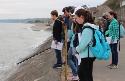 Eighth-grade students look over Omaha Beach at high tide. After being told of the fighting that occured at Omaha, students were given time to silently reflect and think about all the lives lost there (photo by Cloe Tchilikidi).