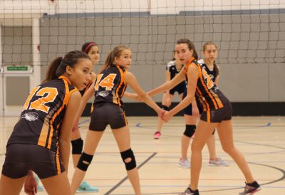 Eighth graders Sofia Salveson, Emma Whitman, and Hadley Bridges are getting ready for their teamate to serve the ball. On September 29 the girls played against the Egham Jaguars at ASL. The final score was 2-1 (Photo by Addie Griggs).